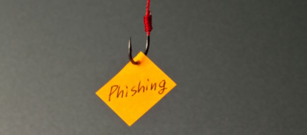 A fishing hook with a post-it note with the word phishing written on