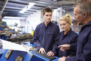 Apprentices listening to their supervisor in a workshop