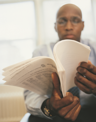 Man sitting down, reading documents