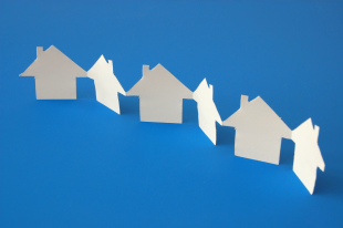 paper chain of white houses on a blue background