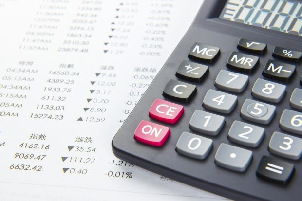 a calculator on top of a finance spreadsheet