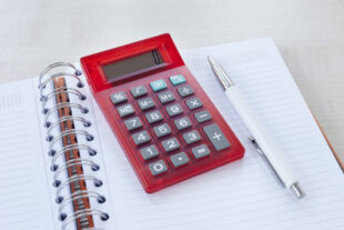 calculator and pen on notebook