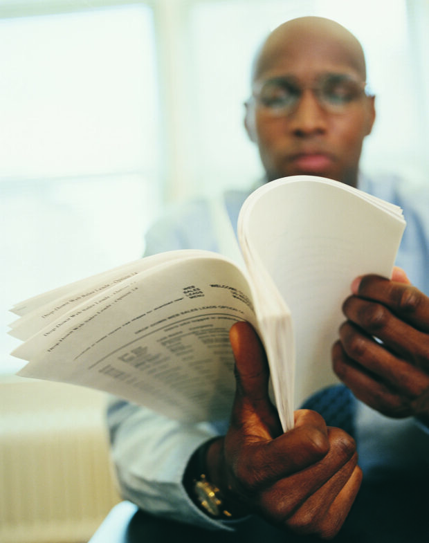 Man sitting down, reading documents