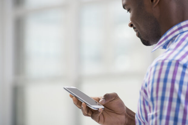 Smiling man looking at a mobile phone