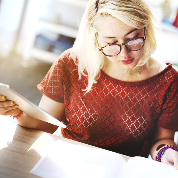 woman sitting at a desk looking through papers