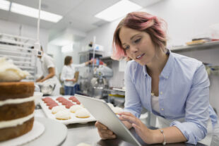 Bakery business owner texting with cell phone